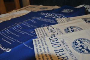 Tea towels printed with a Nanaimo bar recipe printed in blue and white laid out on a table.